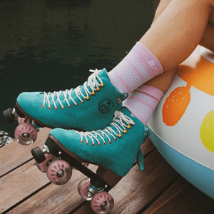 Lifestyle shot of the BTFL Liam Pro Roller skate on feet by water sitting on a pool float